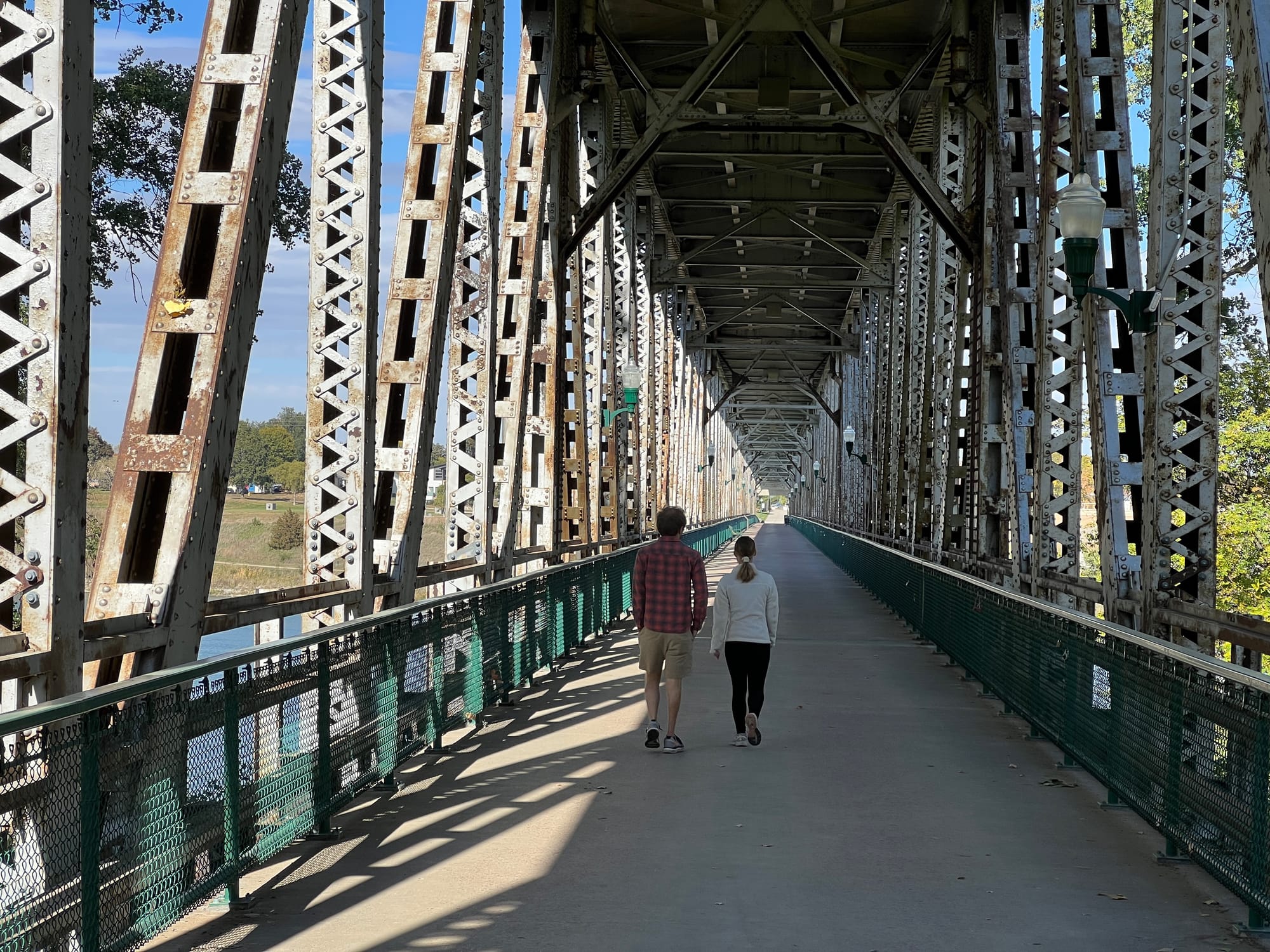 A man and a woman walk down the Meridian Bridge in Yankton, South Dakota.