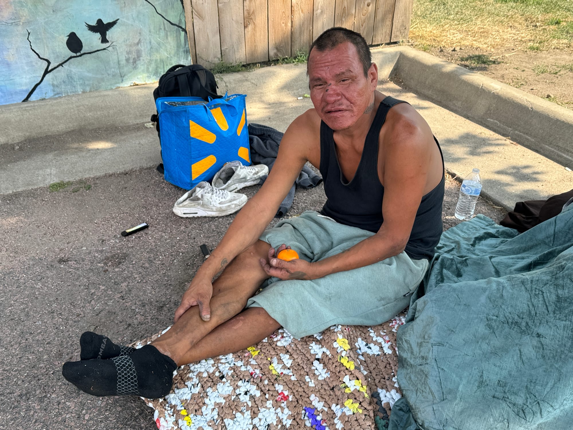 A homeless man sits on the pavement in Sioux Falls, South Dakota