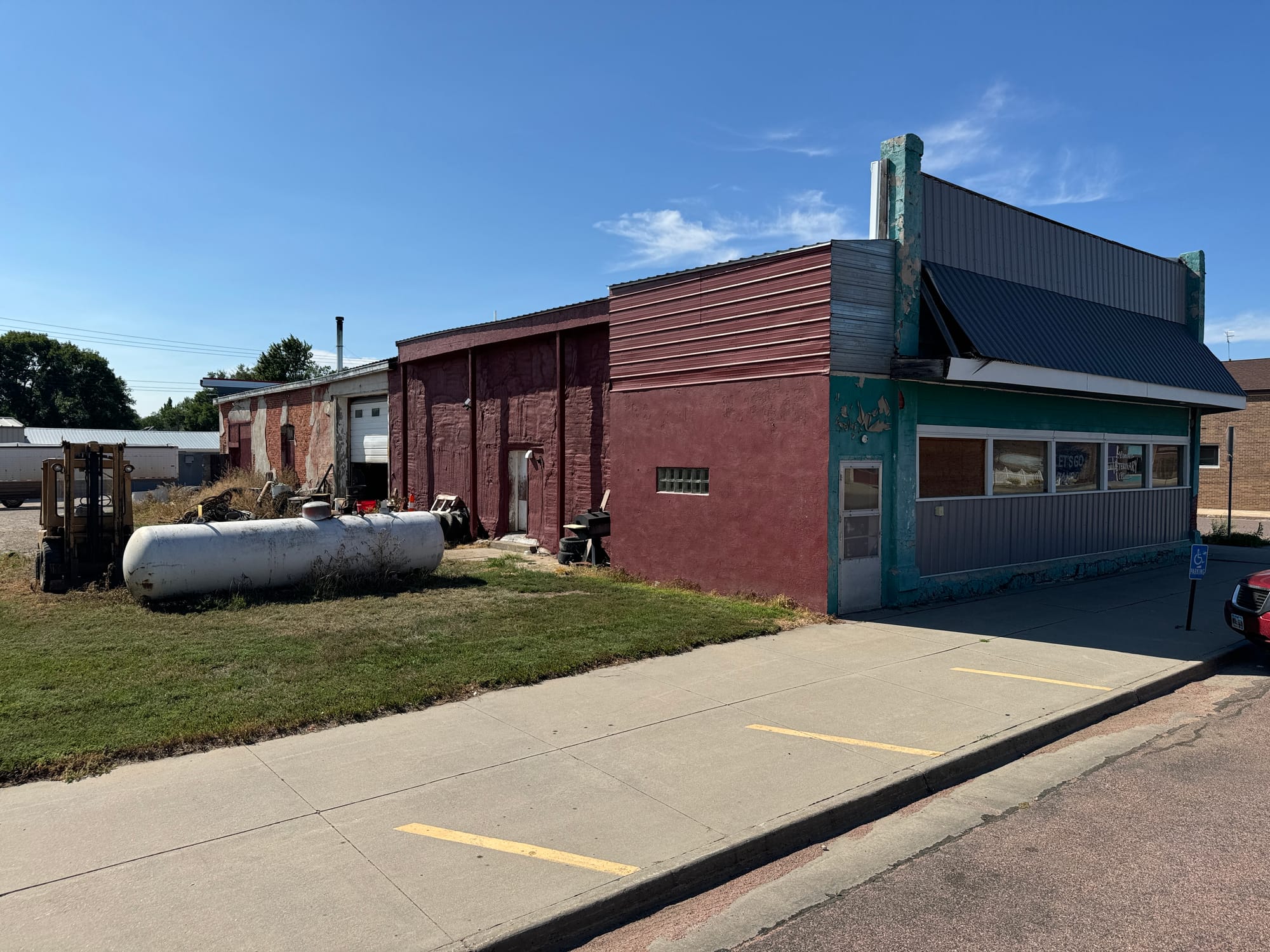 The exterior of a veterinarian shop in Armour, South dakota shows cracked paint and trash on the side.