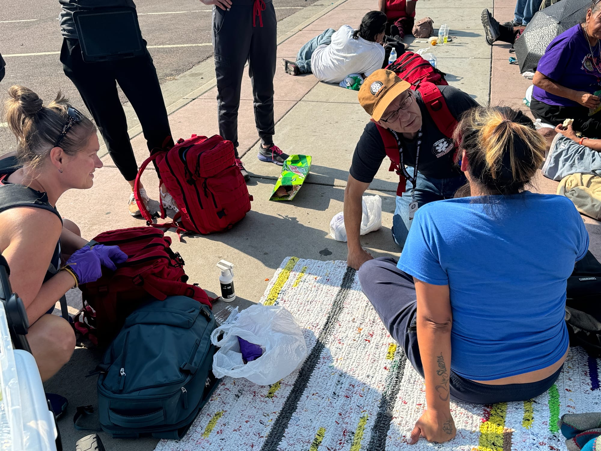 Members of the Midwest Street Medicine Crew tend to a woman who has a stab wound on the face.