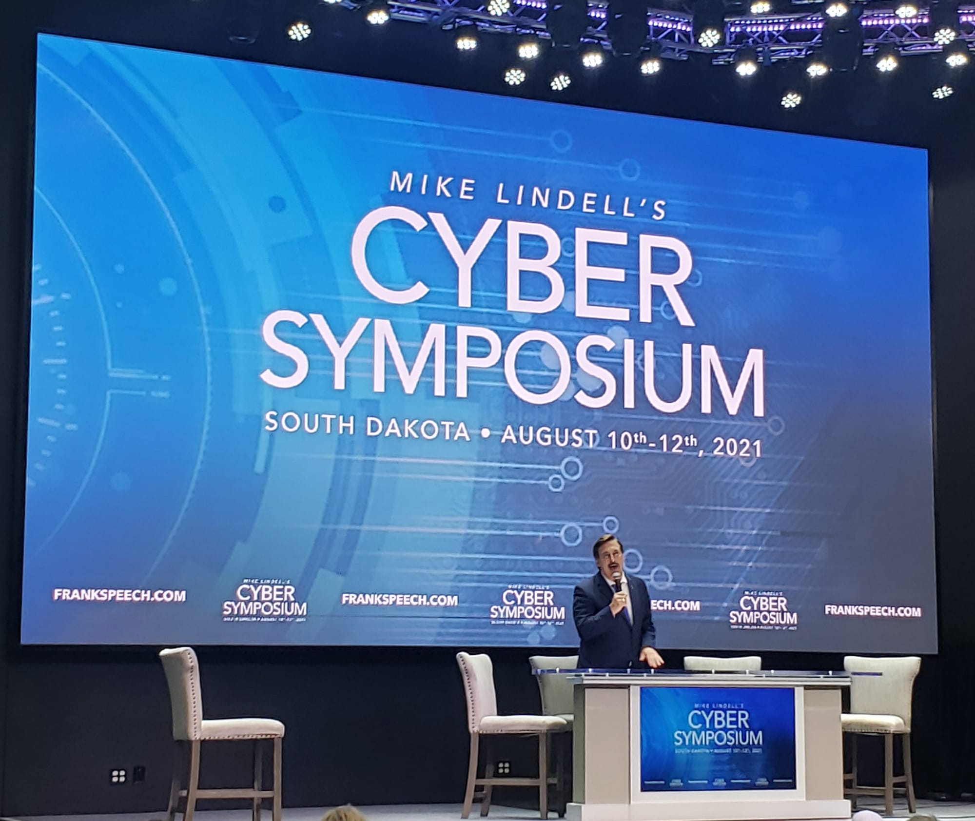 My Pillow founder Mike Lindell speaks in front of a large screen at the Cyber Symposium in Mitchell South Dakota in 2021