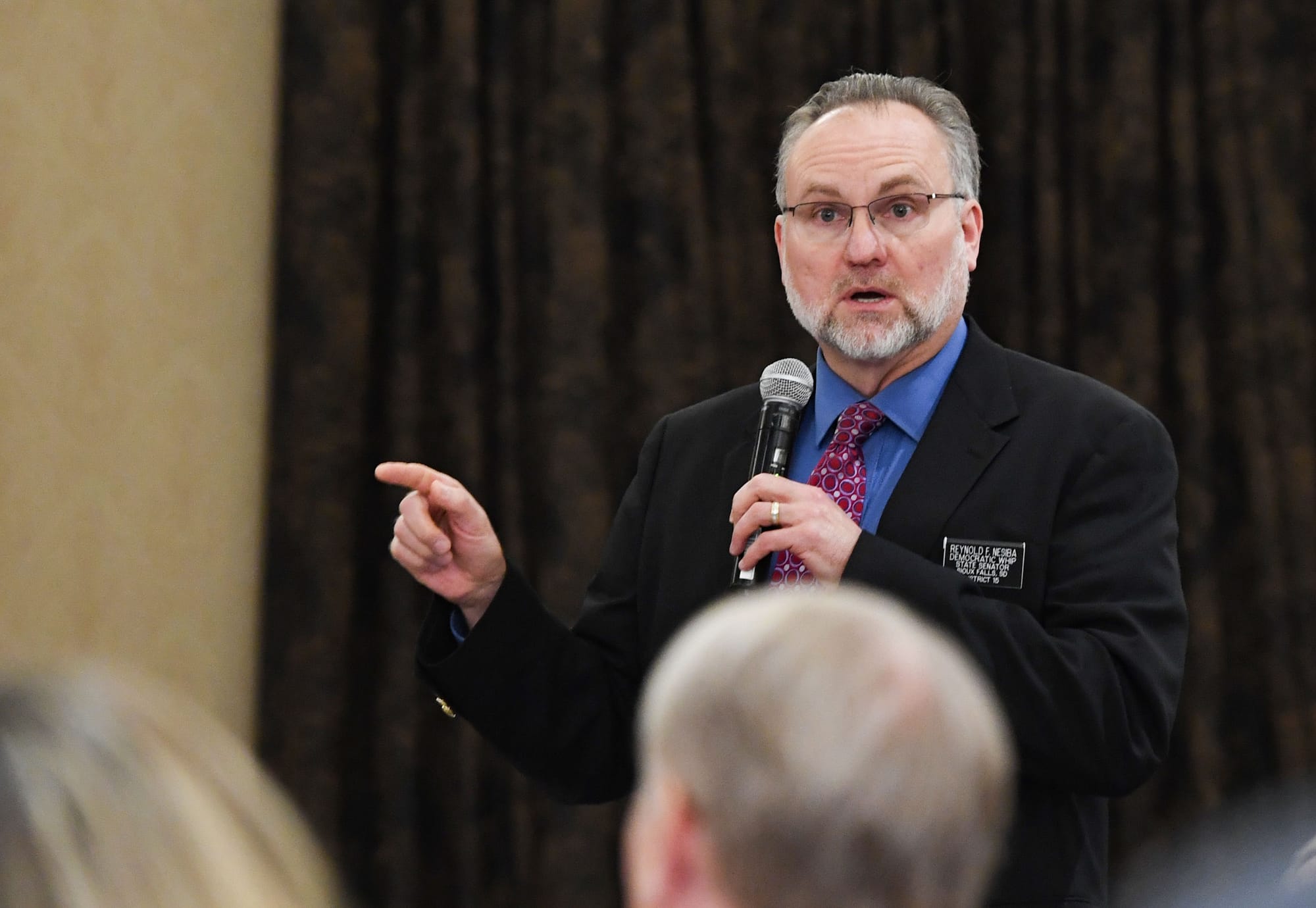 South Dakota Democratic state Sen. Reynold Nesiba gestures while speaking in front of a group