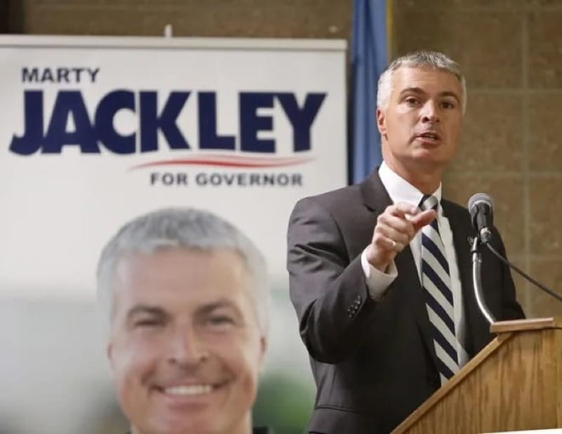 Marty Jackley speaks at a town hall in Aberdeen, South Dakota in front of a podium.