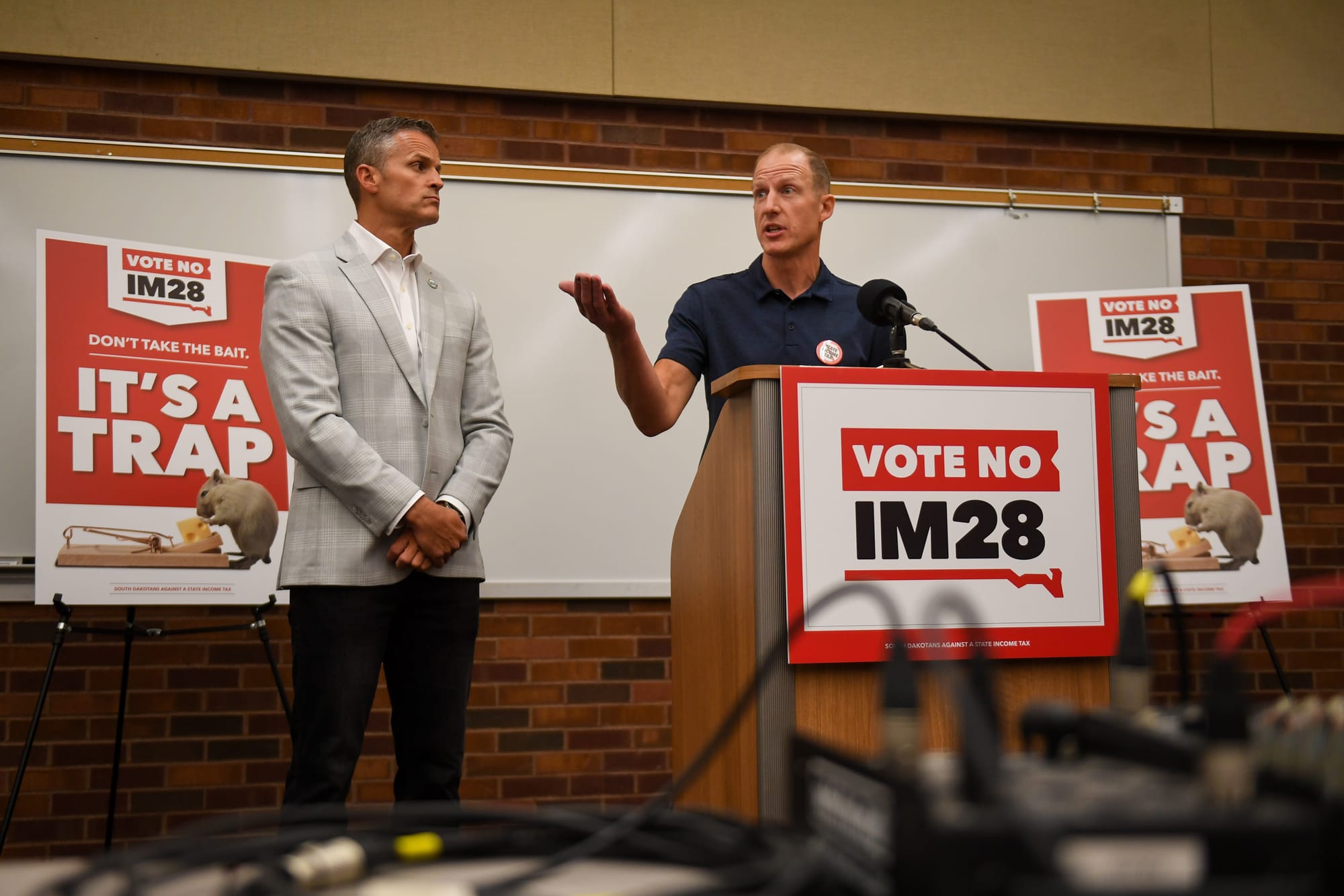 Nathan Sanderson (right), executive director of the South Dakota Retailers Association, speaks against Initiated Measure 28 as Sioux Falls Mayor Paul TenHaken looks on