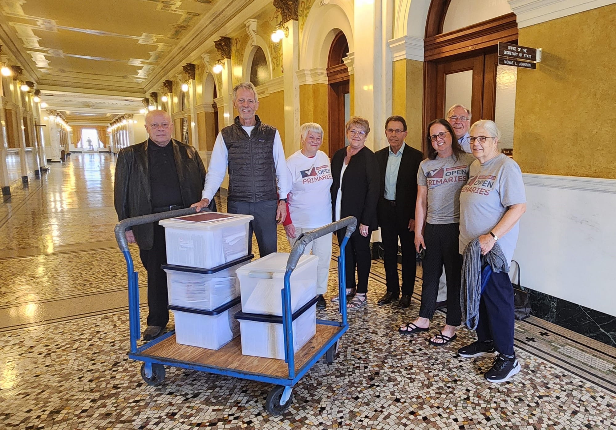 Supporters of the Open Primaries ballot measure pose for a photo with the petition signatures in Pierre.