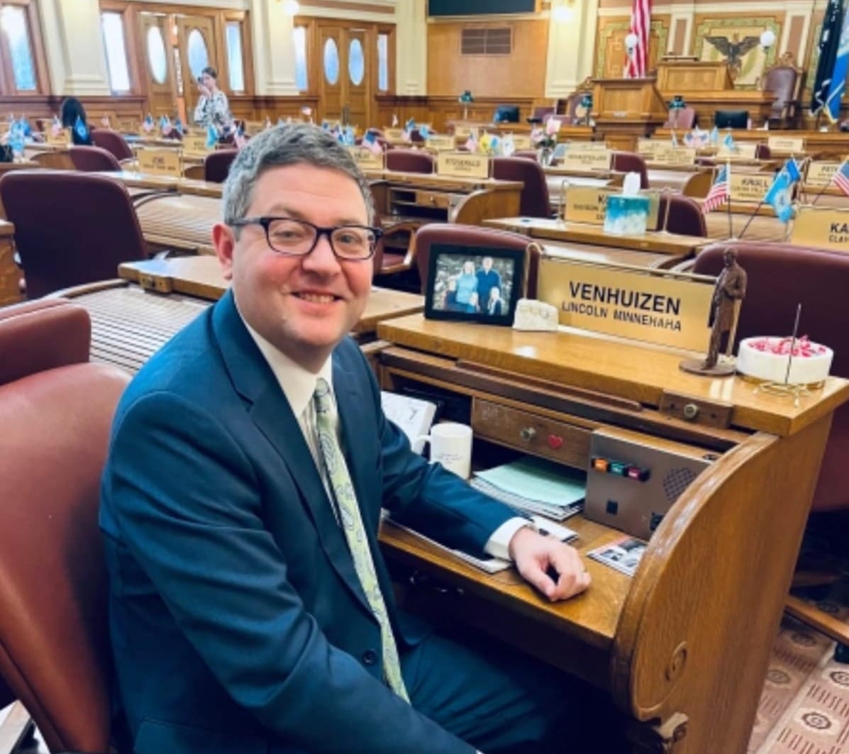 State Rep. Tony Venhuizen looks at the camera as he sits behind his desk at the South Dakota Legislature.