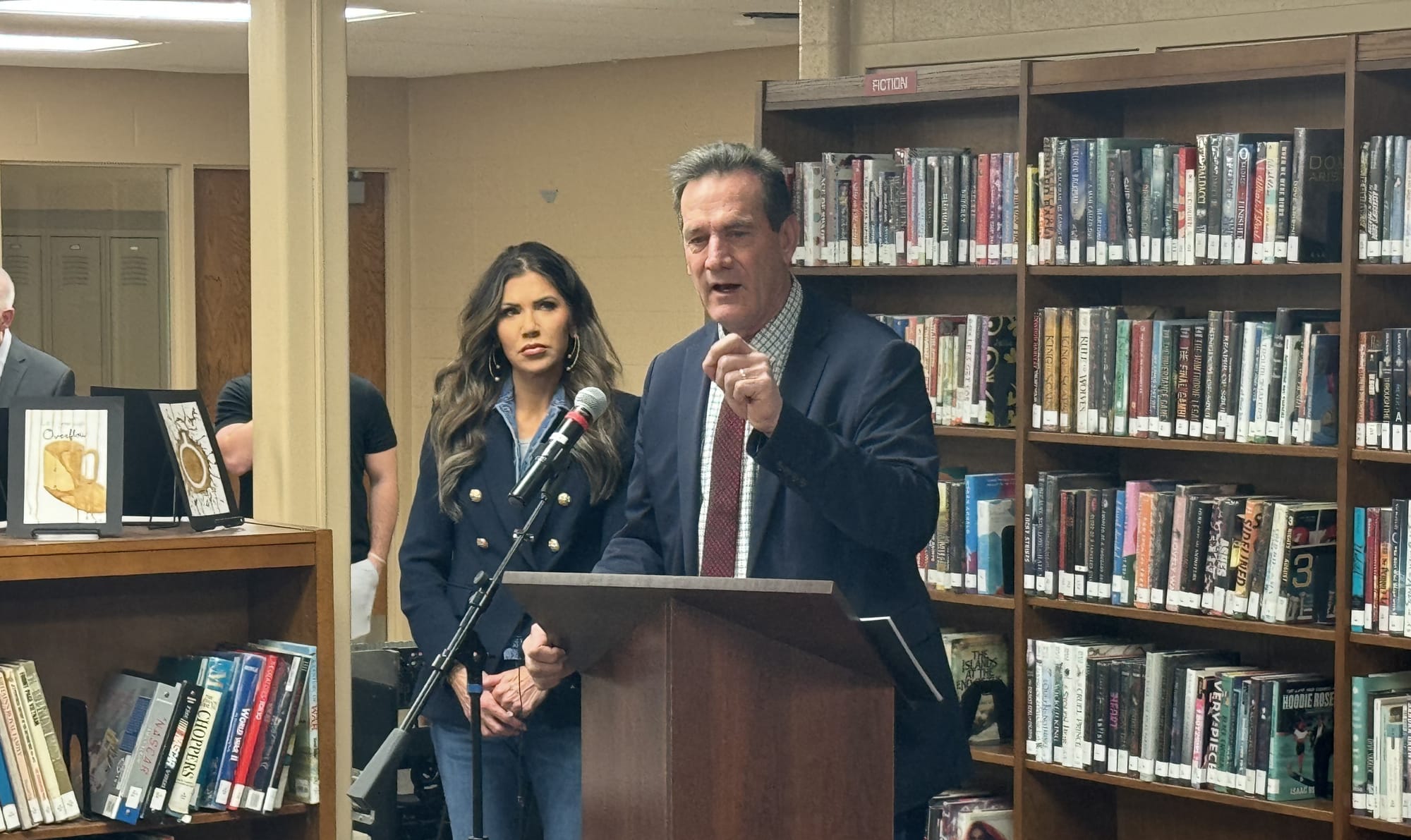 South Dakota Lt. Governor Larry Rhoden speaks at a news conference in a library alongside Gov. Kristi Noem.