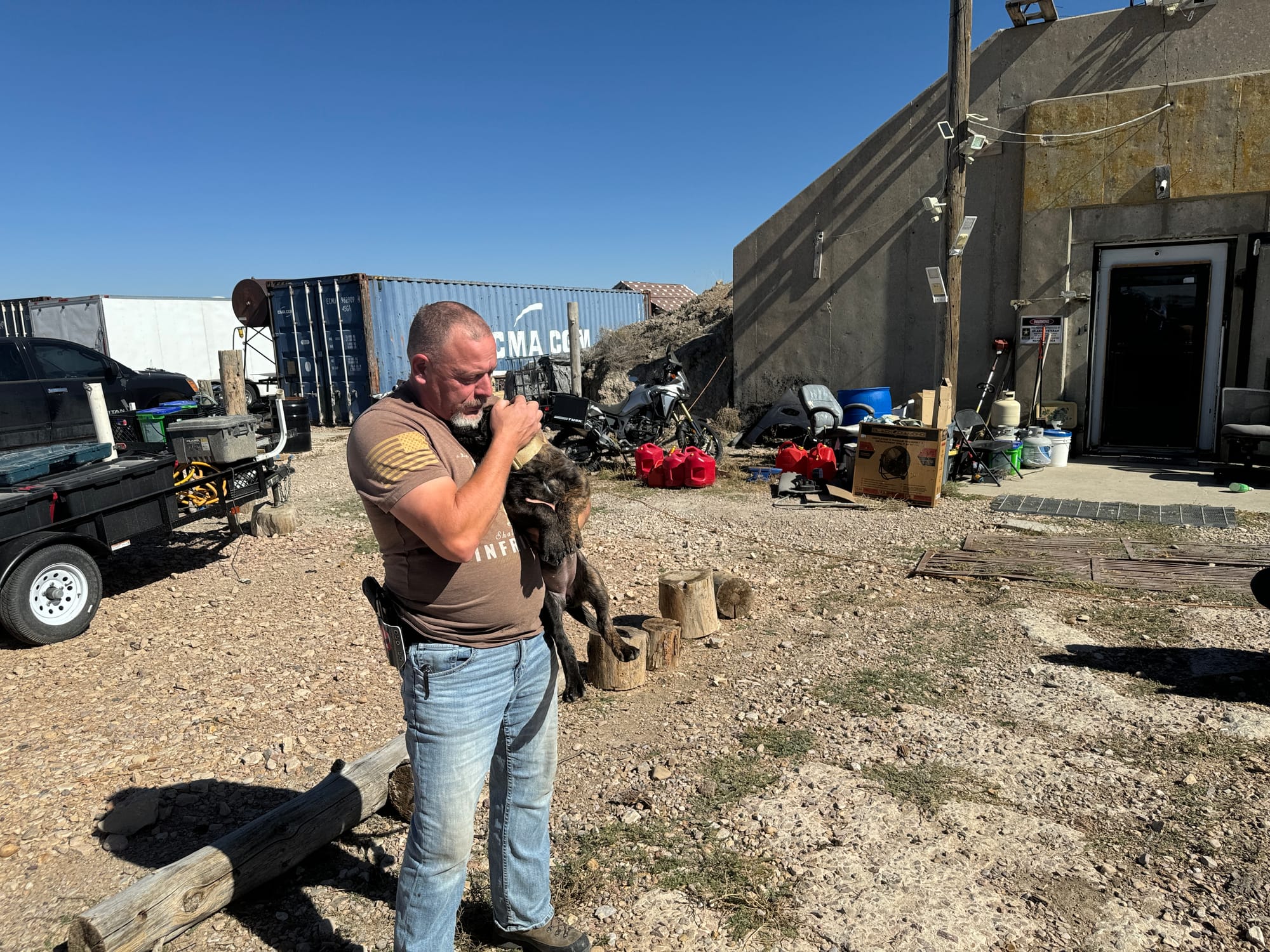 A man holds a puppy outside of a bunker home in Igloo, South Dakota.