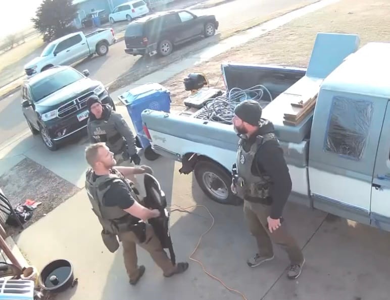 A United States deputy marshal emerges from the house after Zander Zephier was shot and killed Nov. 27, 2024, in Wagner, S.D., and talks with his fellow officers.