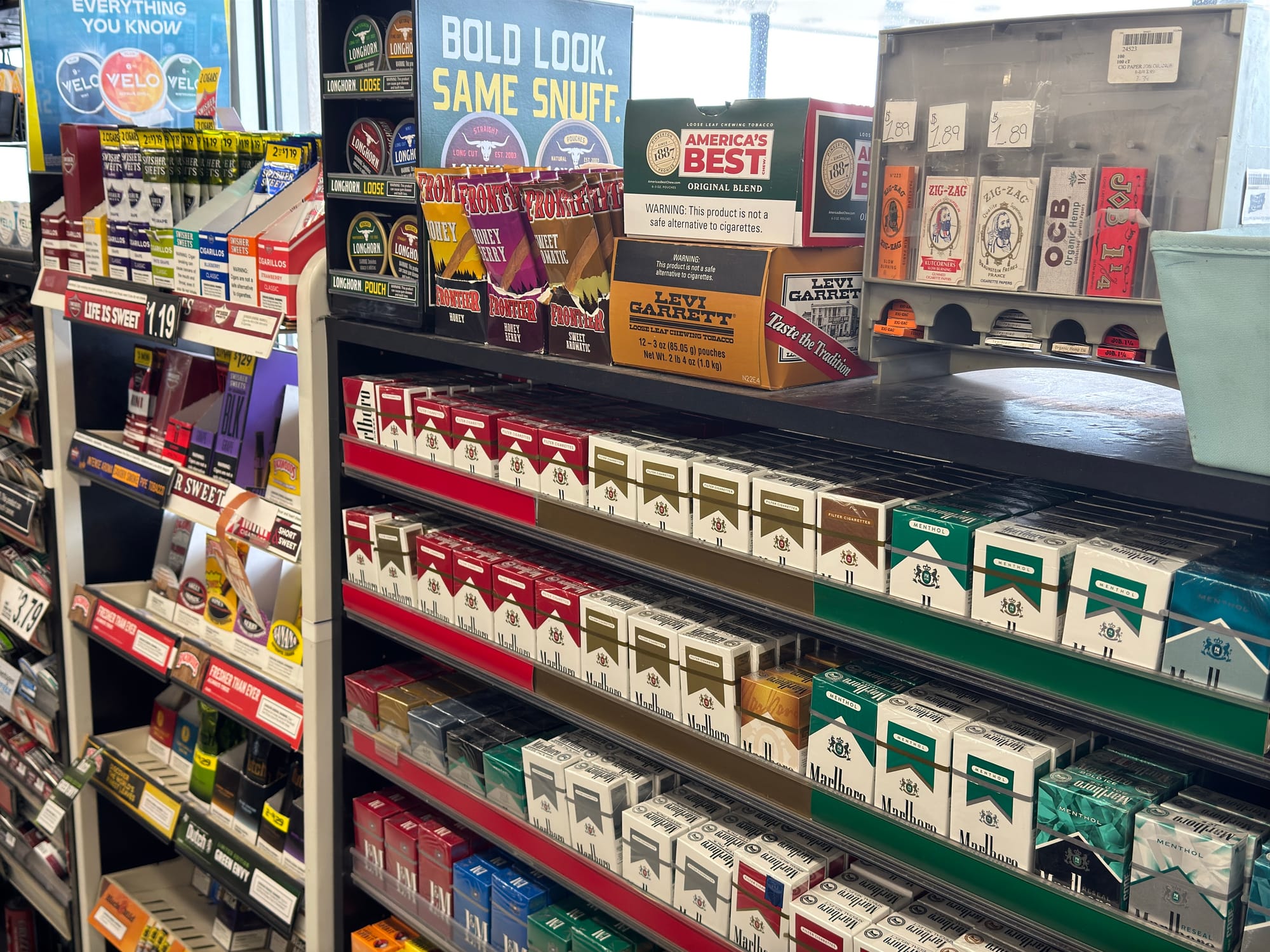 Tobacco products sit on a shelf in a store