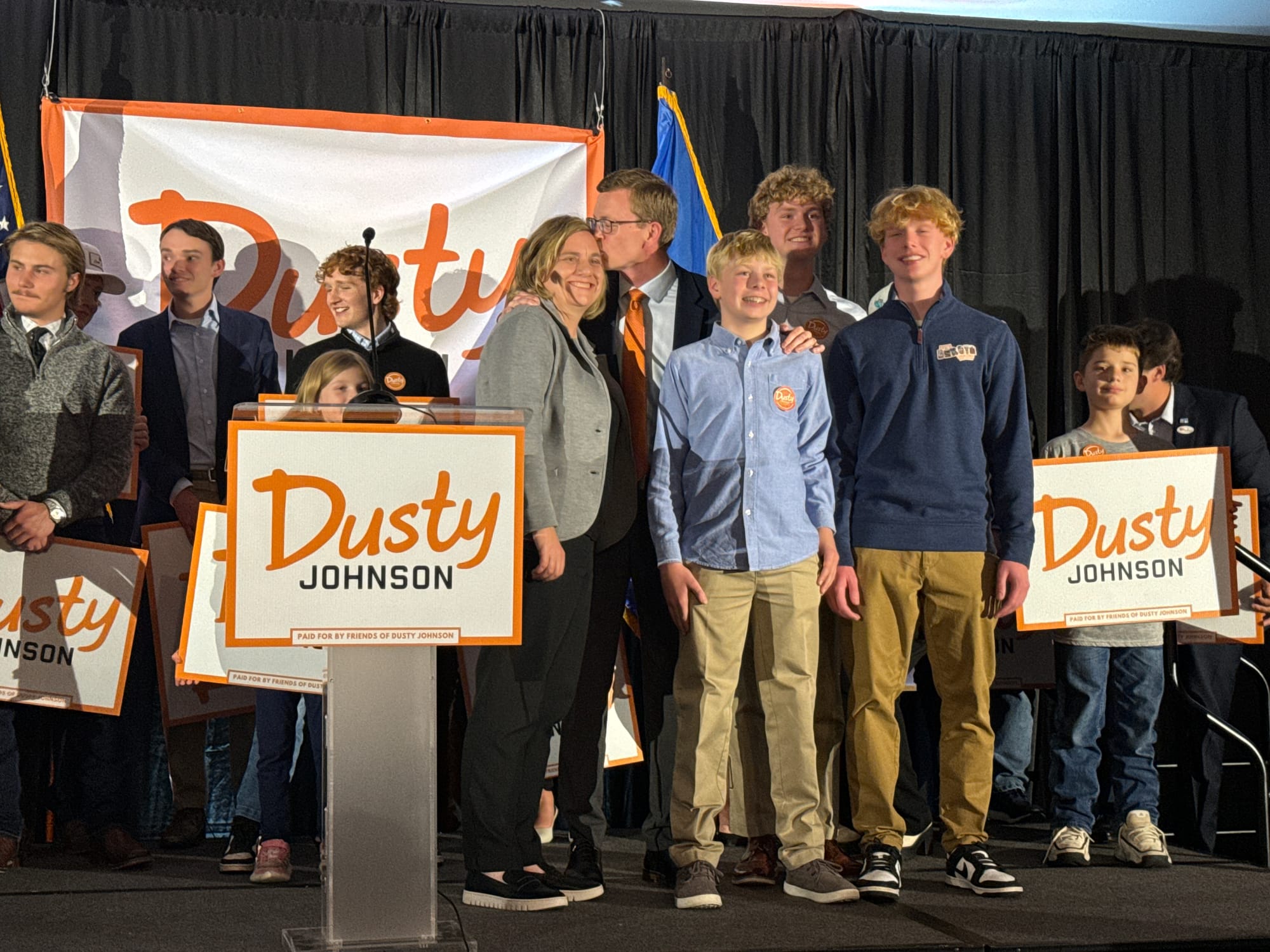 South Dakota Rep. Dusty Johnson kisses his wife, Jacquelyn, next to his three sons after declaring victory in his U.S. House re-election race at the Holiday Inn City Centre in Sioux Falls, S.D., 