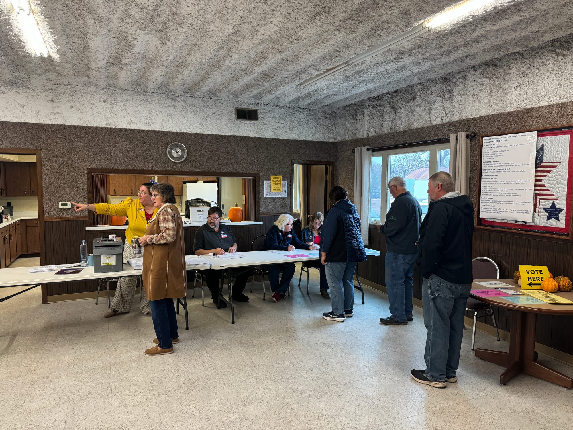 Voters line up to receive their ballots at a precinct inside the American Legion building