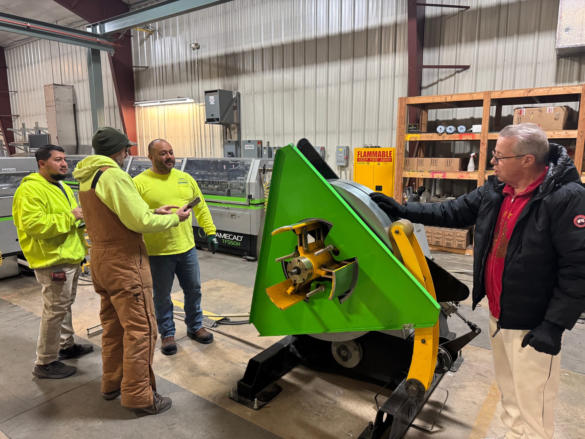 Greg Sands talks with workers in the factory section of Sands Wall Systems on Dec. 12, 2024,