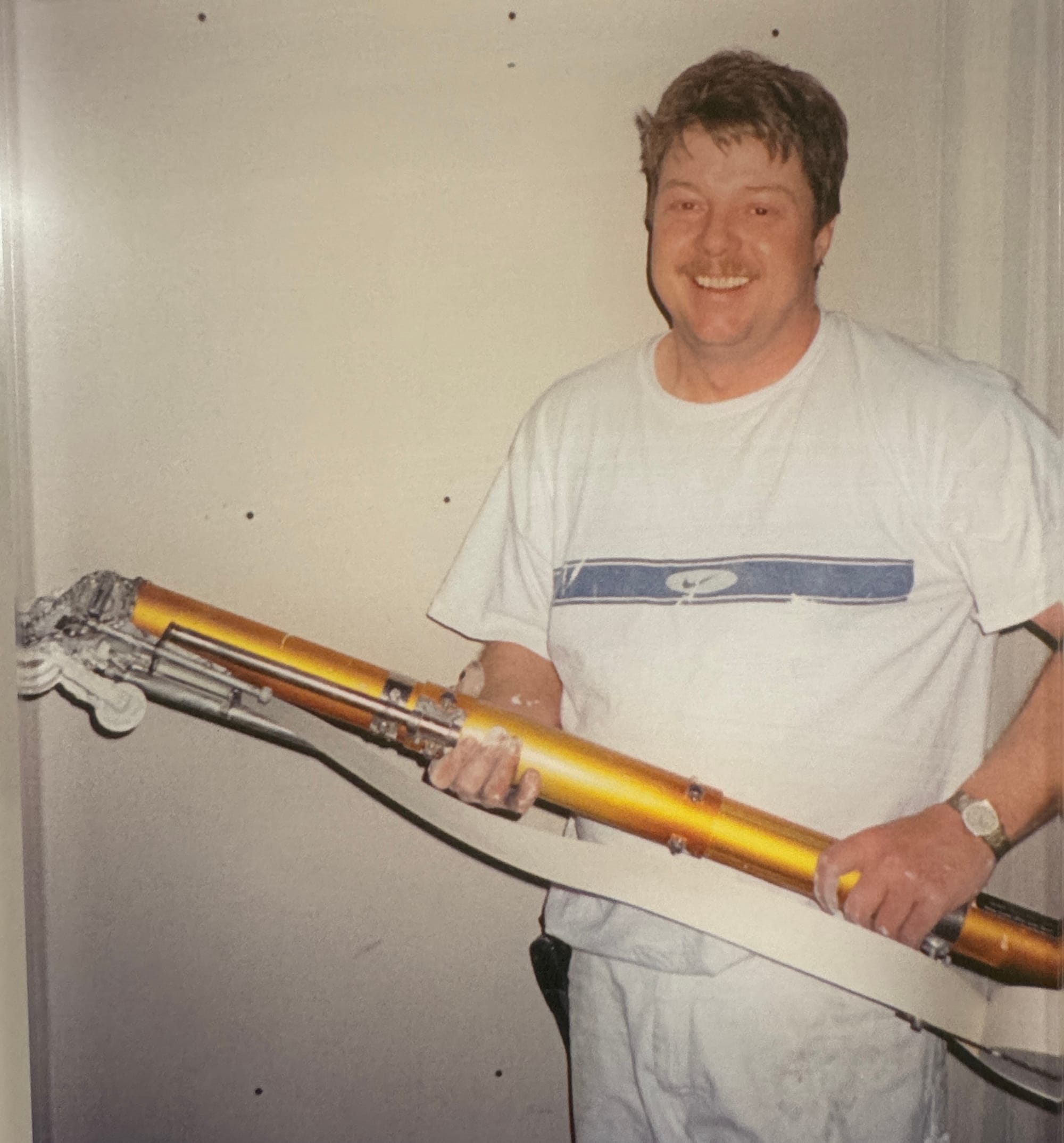 Greg Sands mastered drywall tasks with a bazooka, a specialized tool that applies drywall tape and joint compound at the same time for faster finishing. 