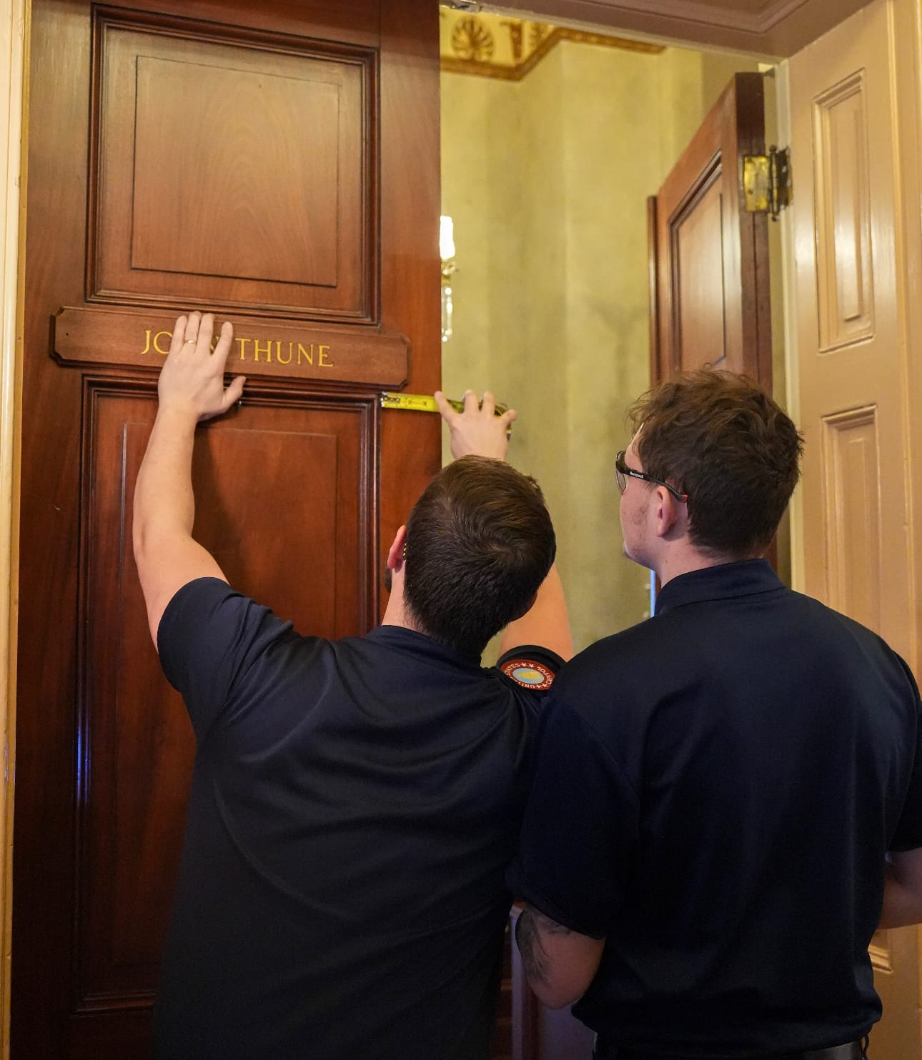 Workers install Sen. John Thune's nameplate on the door of the Senate Republican Leaders suite at the U.S. Capitol 