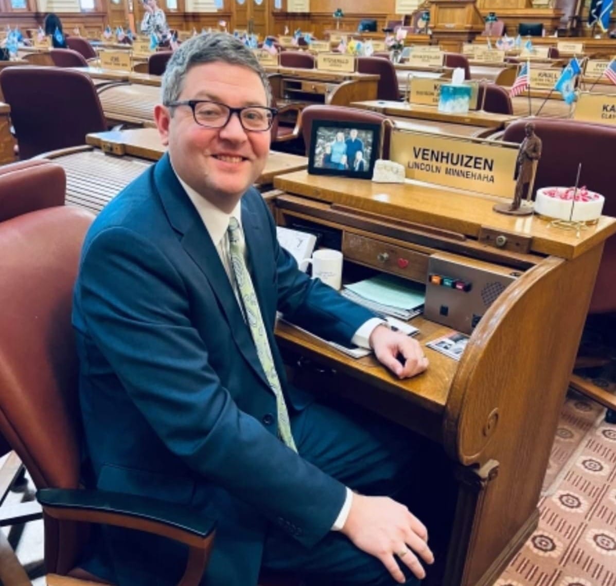 A South Dakota legislator poses for a photo at his desk in Pierre, South Dakota