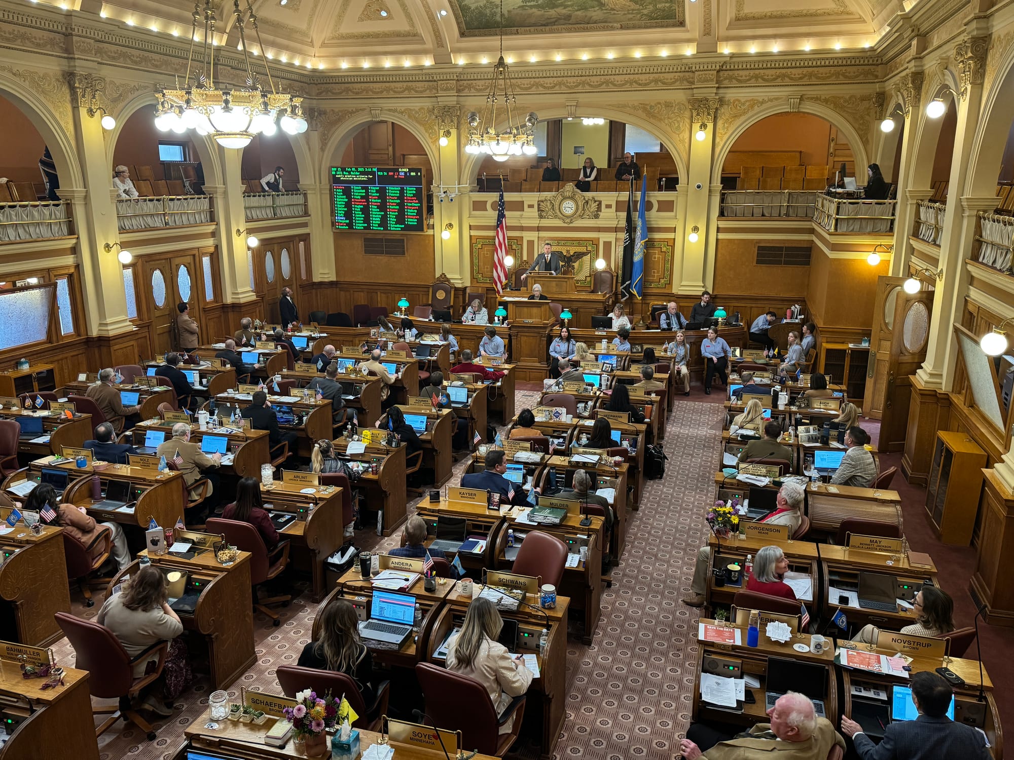 Legislators sit at desks at the South Dakota state legislature