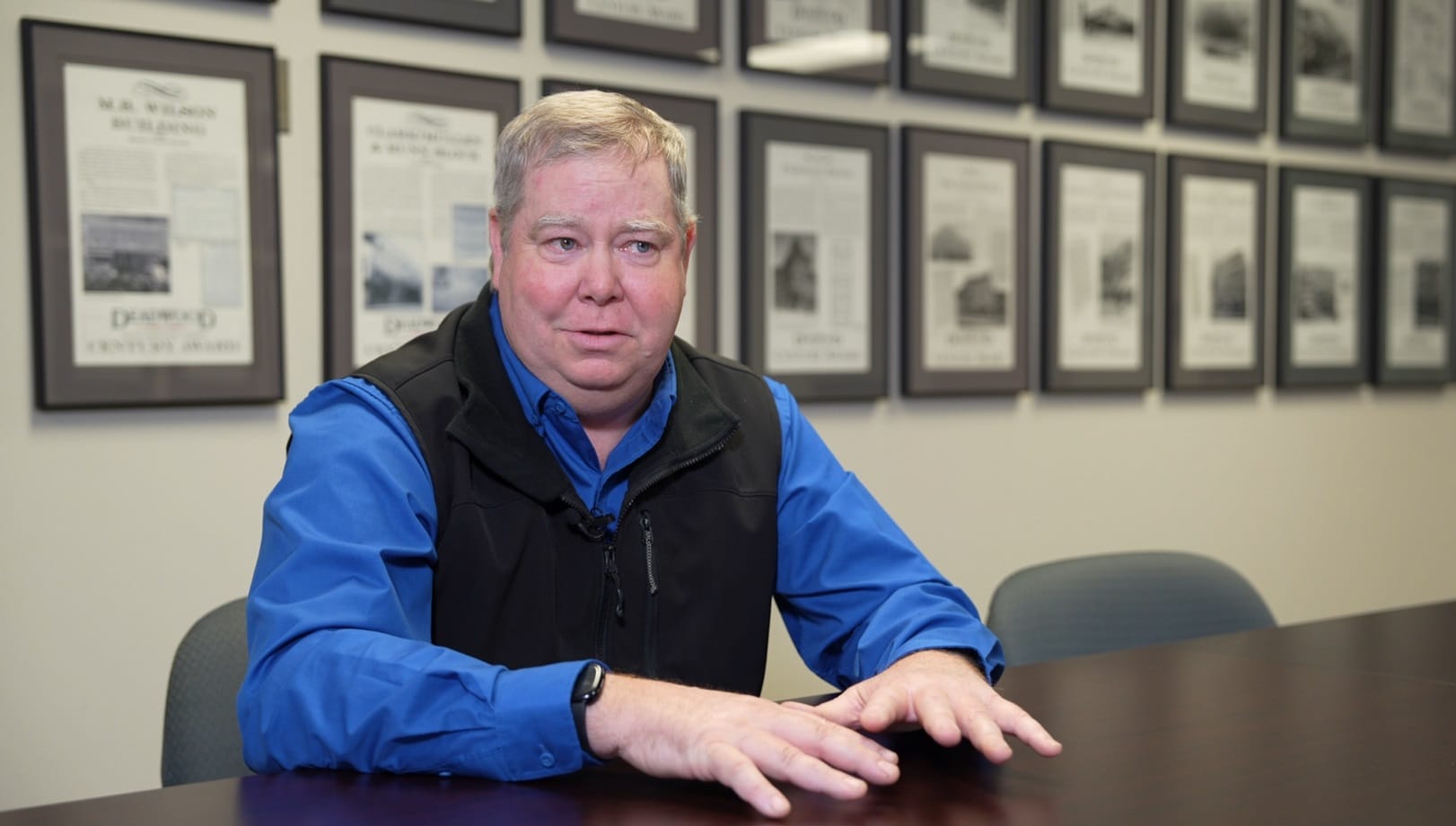 Kevin Kuchenbecker sits at a table and gestures during an interview in a conference room