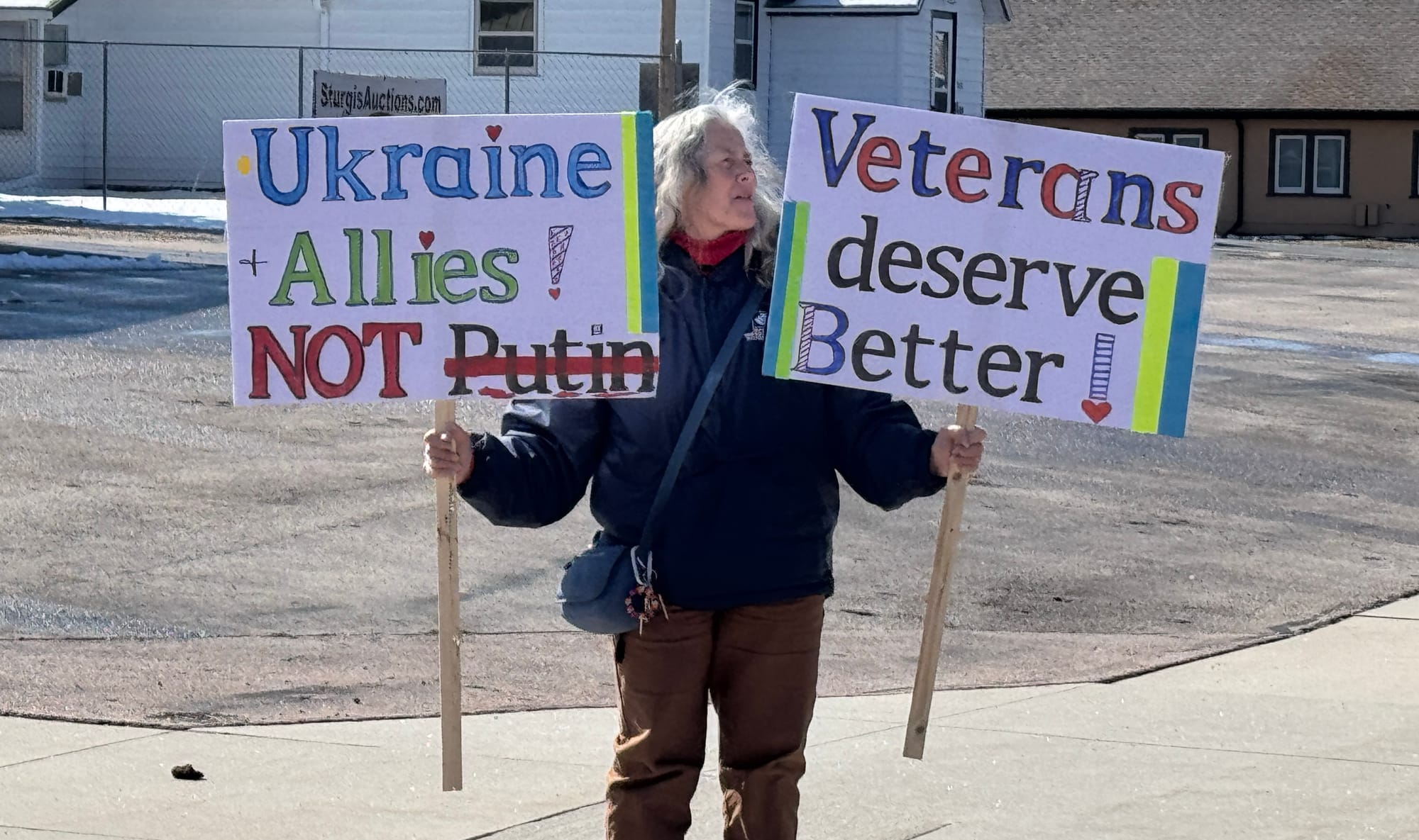 A protester stands on March 19, 2025, outside the Veteran's Center in Sturgis, S.D.,