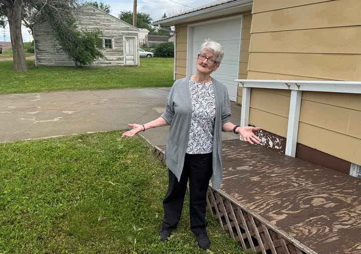Loretta Passolt, 70, stands outside her house in Faith, South Dakota..