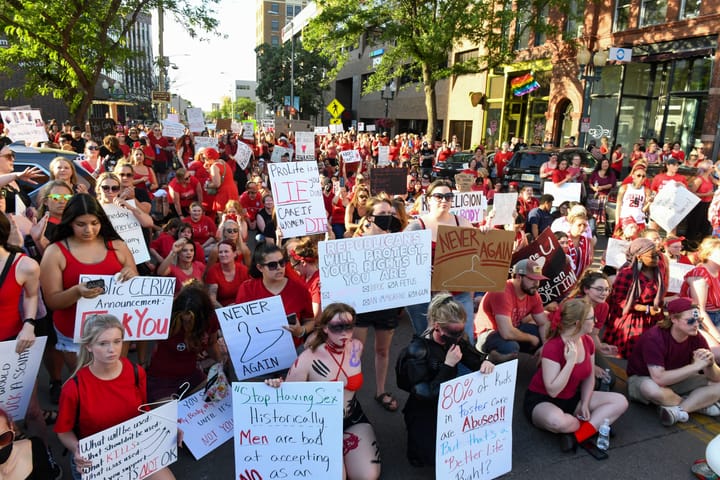 Hundreds dressed in red block a portion of a Sioux Falls street to protest the overturning Roe v. Wade.