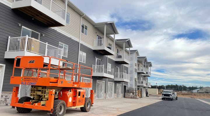 Construction crews prepare to work on the exterior of an apartment complex