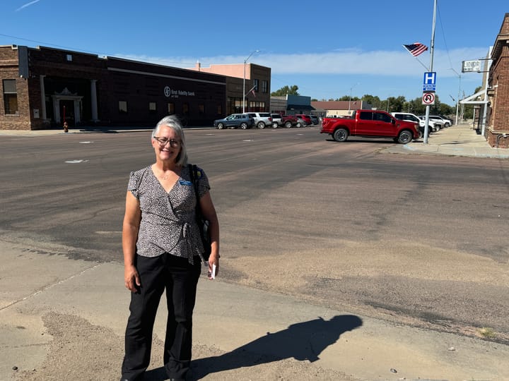 Democratic U.S. House candidate Sheryl Johnson stands on Main Street in Burke, S.D., during a campaign stop