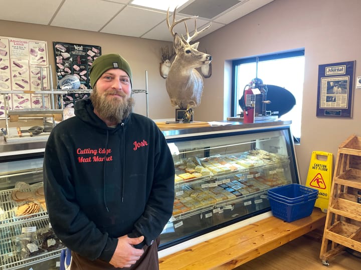 Josh Clark stands in front of the display case at the Cutting Edge Meat Market in Piedmont, S.D.